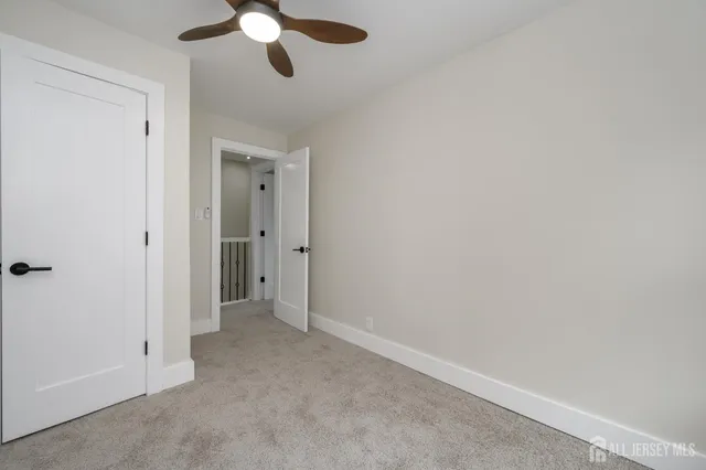 an empty room with a chandelier fan and closet area