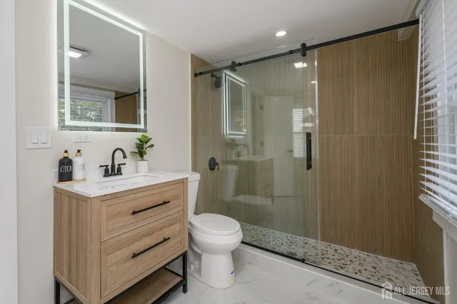 a bathroom with a sink toilet a mirror and shower