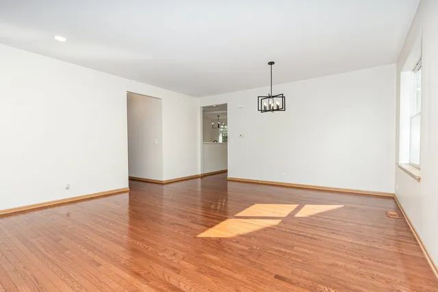 a view of empty room with wooden floor and ceiling fan