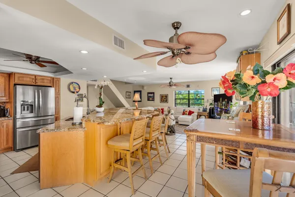 a view of a dining room with furniture a chandelier and kitchen view