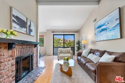 a living room with furniture a fireplace and a large window