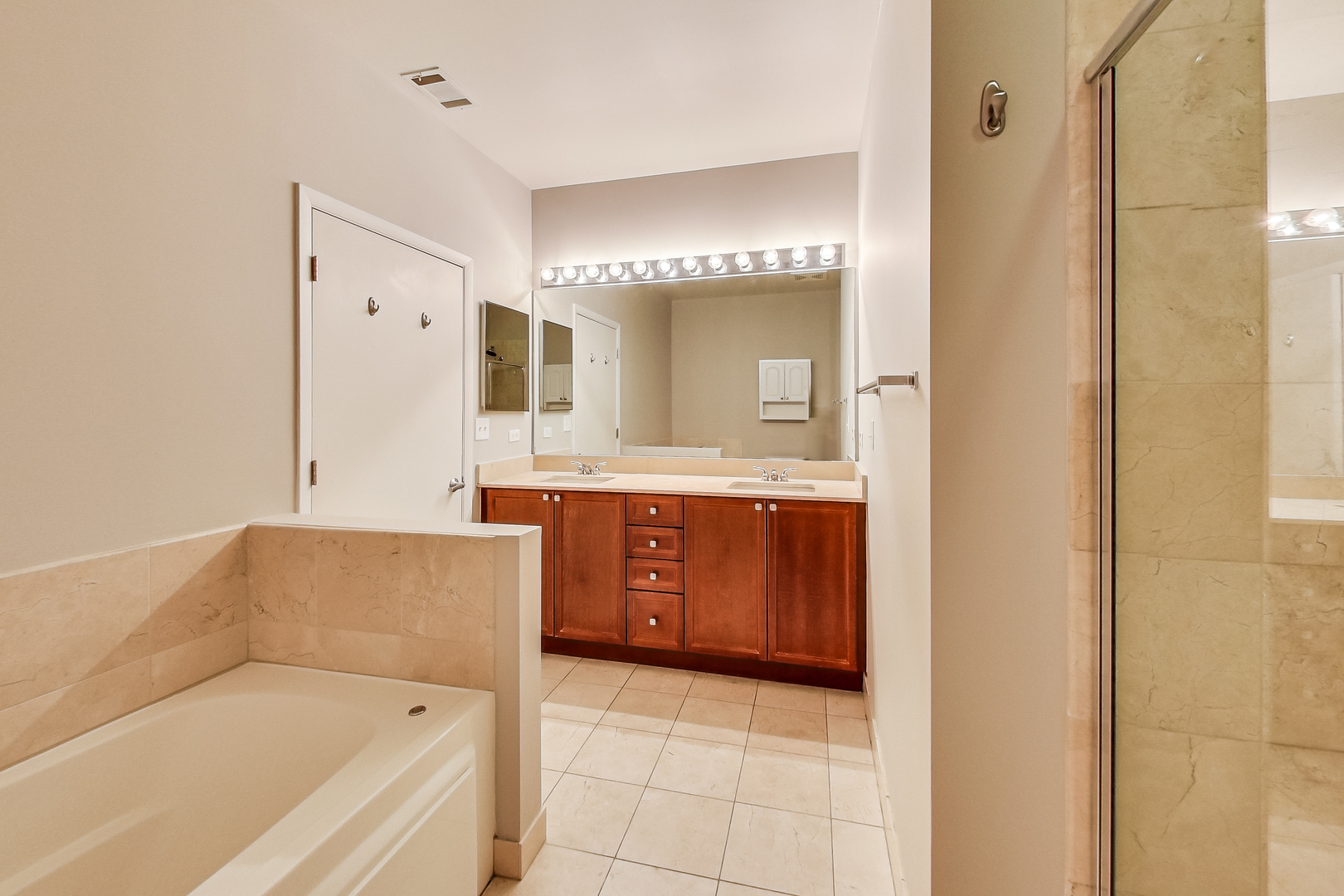 950 West Monroe Street, Unit 903 Chicago, IL 60607 - Photo 15 of 27 a en suite bathroom with a tub double sink and mirror