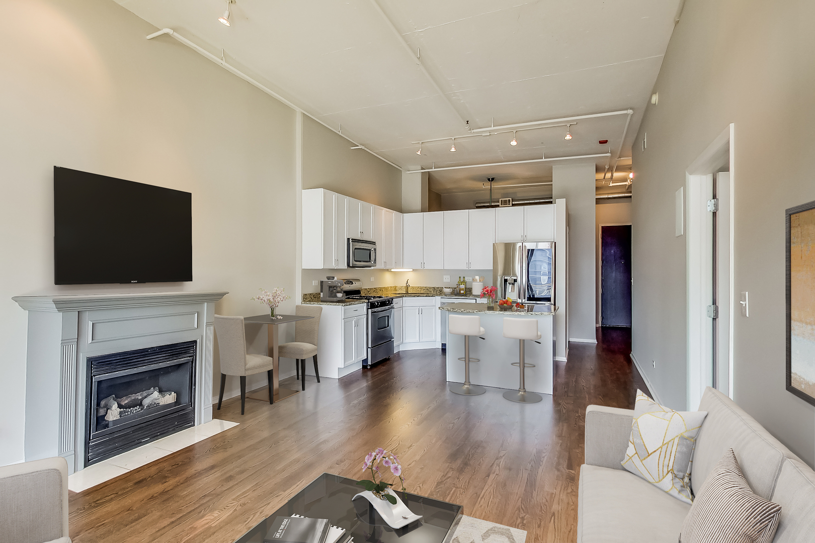 950 West Monroe Street, Unit 903 Chicago, IL 60607 - Photo 4 of 27 a living room with stainless steel appliances furniture a fireplace a flat screen tv and view kitchen