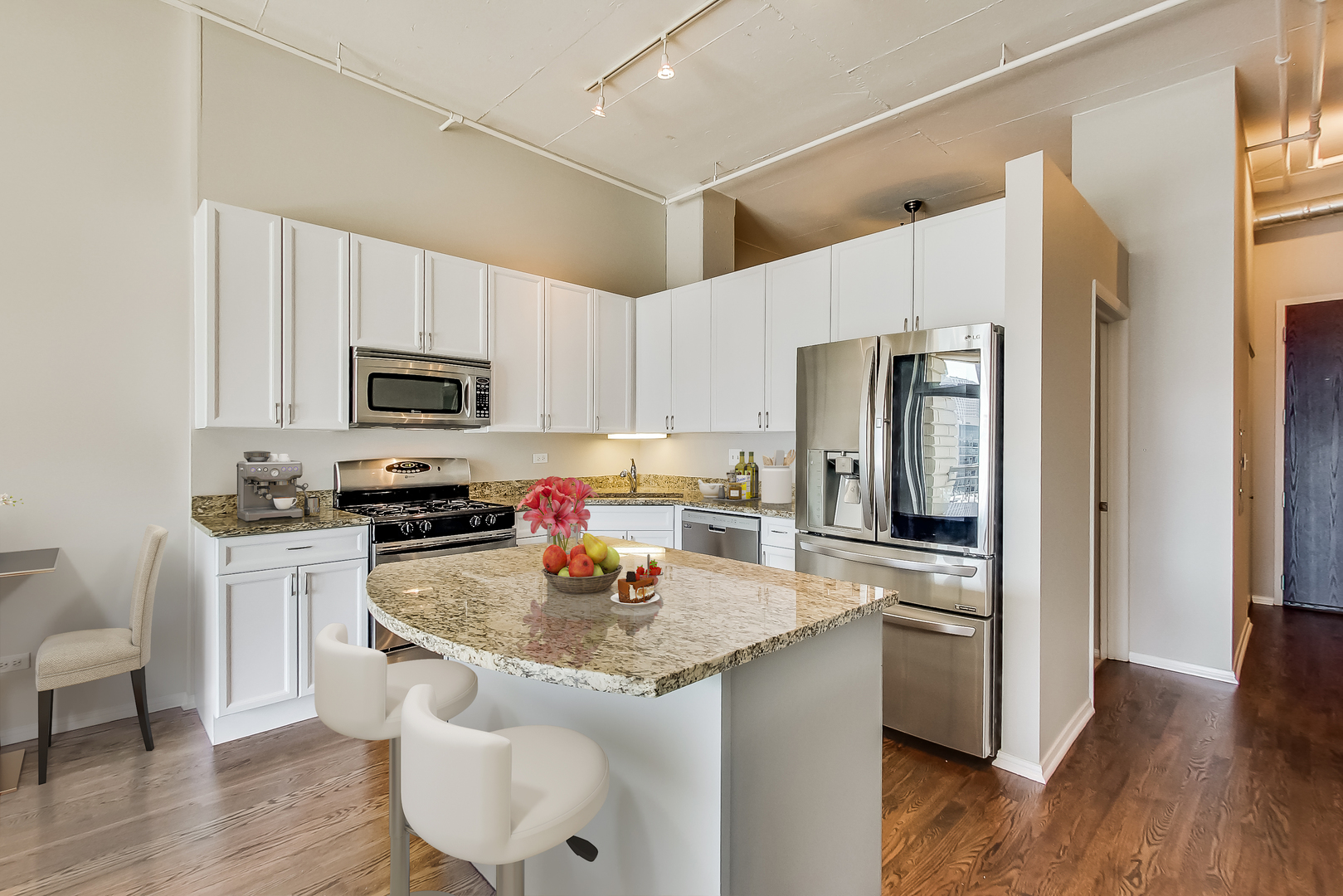950 West Monroe Street, Unit 903 Chicago, IL 60607 - Photo 5 of 27 a kitchen with a refrigerator a stove top oven a sink dishwasher and wooden cabinets with wooden floor