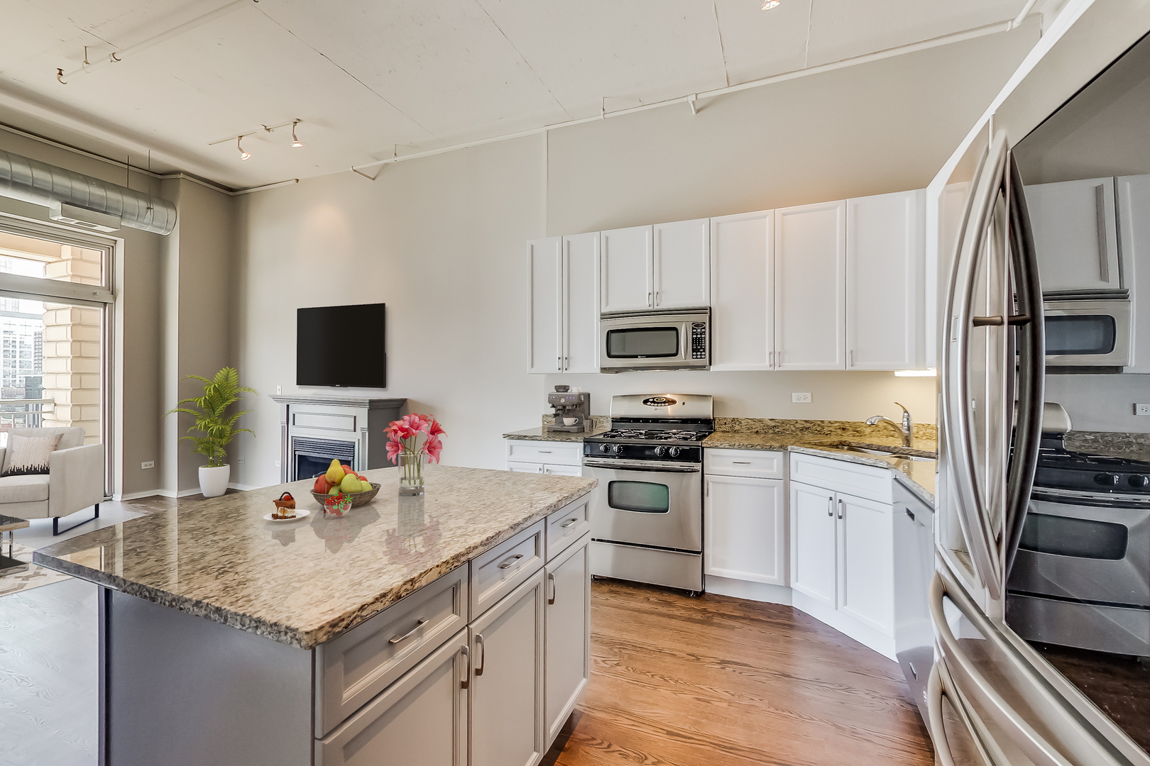 950 West Monroe Street, Unit 903 Chicago, IL 60607 - Photo 7 of 27 a kitchen with stainless steel appliances granite countertop a sink stove microwave and refrigerator