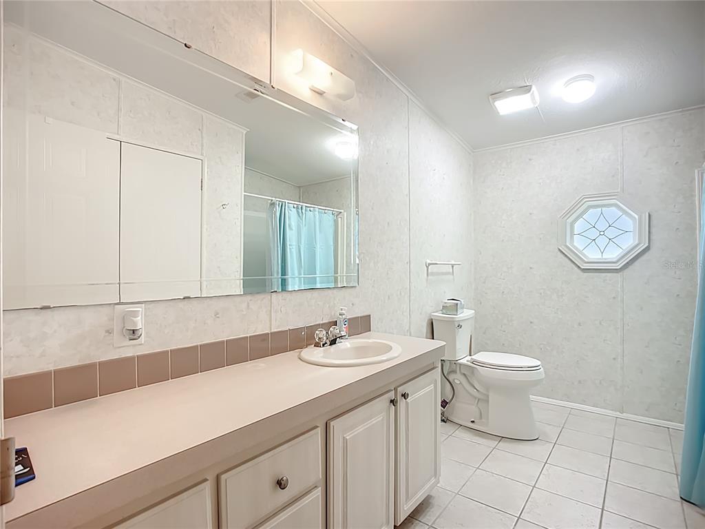 8307 Nancy Lane Ellenton, FL 34222 - Photo 24 of 56 a bathroom with a double vanity sink a toilet and a mirror