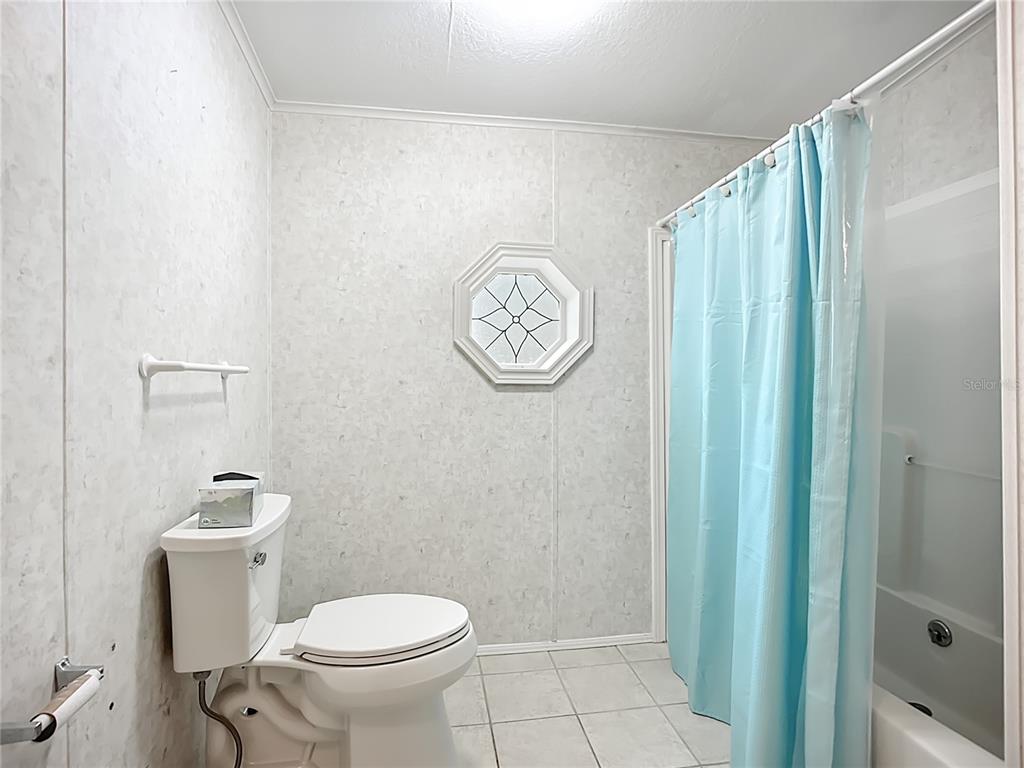 8307 Nancy Lane Ellenton, FL 34222 - Photo 25 of 56 a white toilet sitting next to a shower curtain
