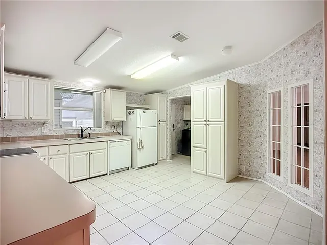 a kitchen with a refrigerator sink and cabinets