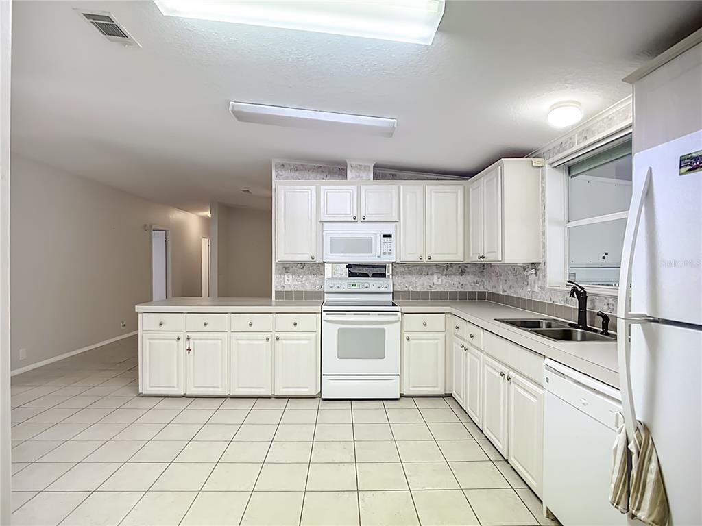 8307 Nancy Lane Ellenton, FL 34222 - Photo 6 of 56 a kitchen with cabinets stainless steel appliances a sink and a stove