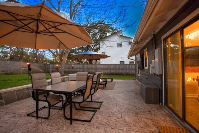 a view of a patio with a table and chairs under an umbrella