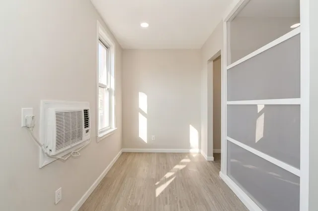 a view of a bedroom with wooden floor and windows