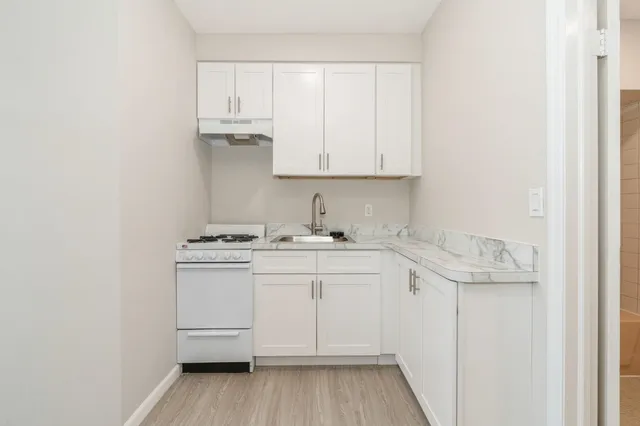 a kitchen with a sink cabinets and wooden floor