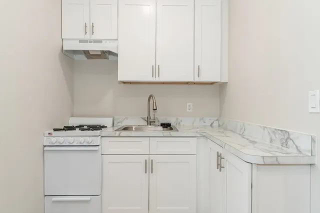 a kitchen with stainless steel appliances granite countertop white cabinets sink and dishwasher
