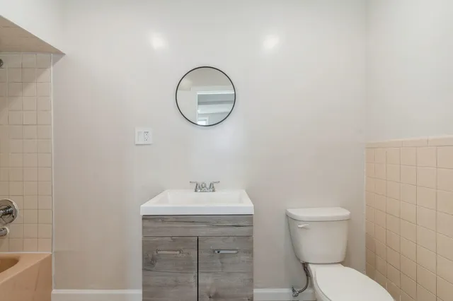 a bathroom with a toilet a sink and mirror