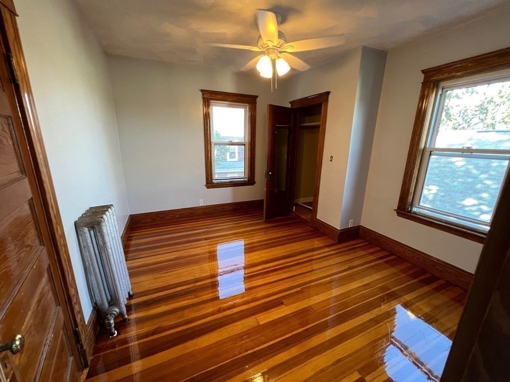 26 Sycamore Street, Unit 2 Somerville, MA 02143 - Photo 4 of 9 a view of an empty room with wooden floor and a window