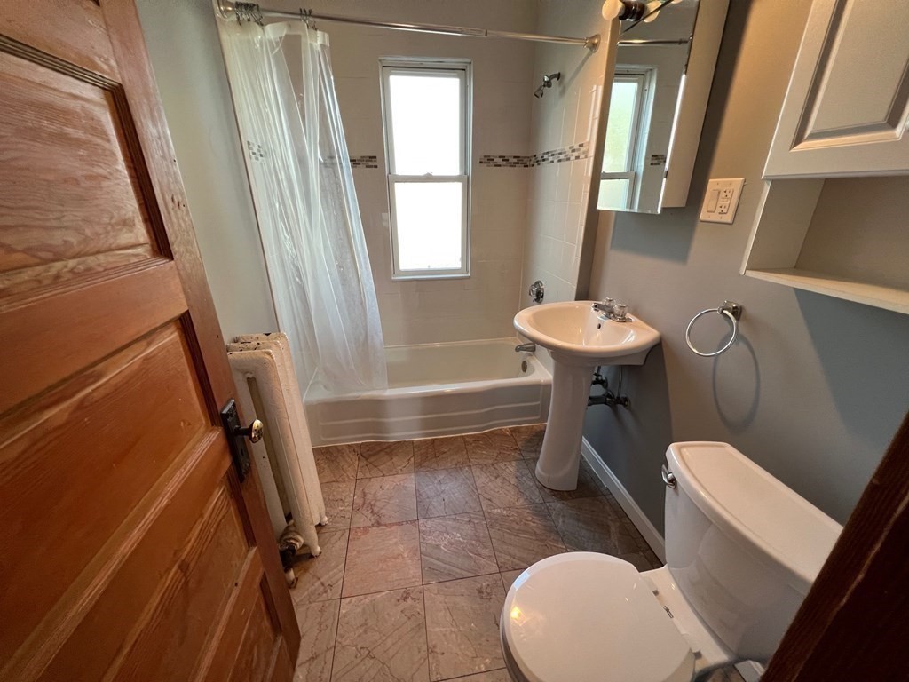 26 Sycamore Street, Unit 2 Somerville, MA 02143 - Photo 5 of 9 a bathroom with a sink a toilet a mirror and a tub