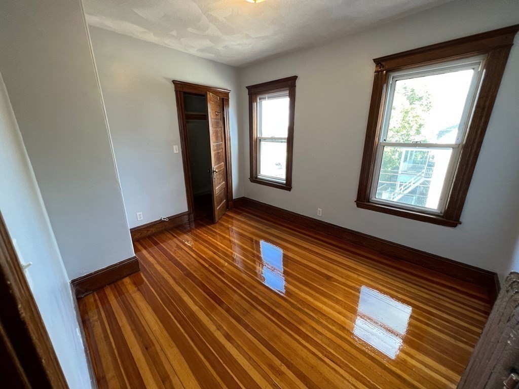 26 Sycamore Street, Unit 2 Somerville, MA 02143 - Photo 7 of 9 a view of an empty room with wooden floor and a window