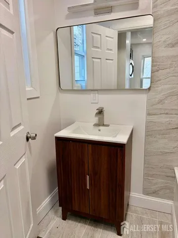 a bathroom with a sink vanity and mirror
