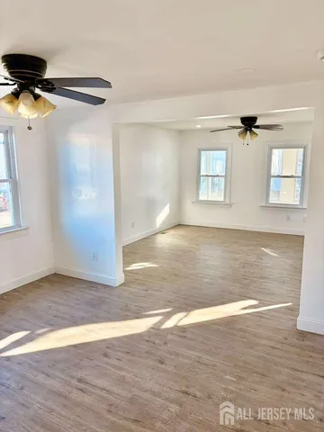 a view of a room with wooden floor and a ceiling fan