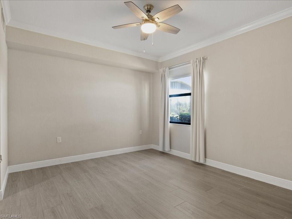 9719 Acqua Court, Unit 218 Naples, FL 34113 - Photo 11 of 23 Empty room featuring light wood-style floors, ornamental molding, and ceiling fan