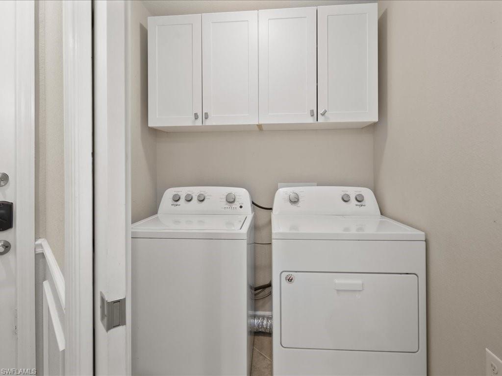 9719 Acqua Court, Unit 218 Naples, FL 34113 - Photo 22 of 23 Laundry room with cabinet space and washing machine and clothes dryer