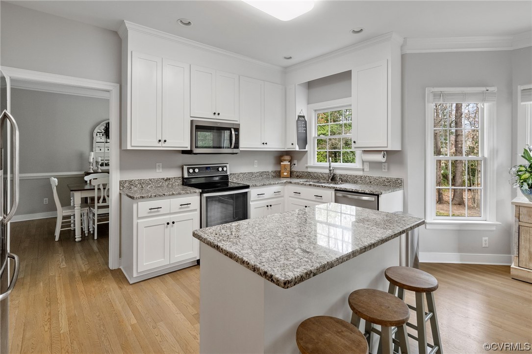 820 Club Ridge Court Chester, VA 23836 - Photo 11 of 38 a kitchen with stainless steel appliances granite countertop a stove top oven a sink dishwasher and white cabinets with wooden floor