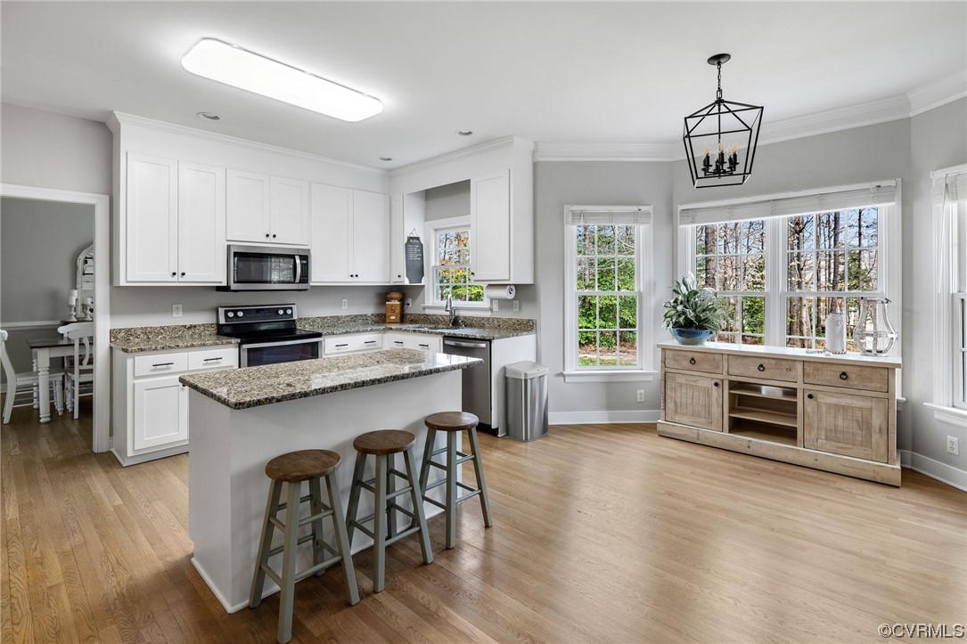 820 Club Ridge Court Chester, VA 23836 - Photo 13 of 38 a kitchen with kitchen island granite countertop a stove top oven a sink a counter space and cabinets