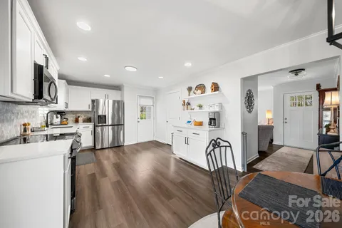 a view of a kitchen with kitchen island stainless steel appliances refrigerator stove microwave and cabinets