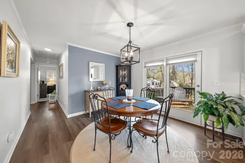 a dining room with furniture potted plants and wooden floor