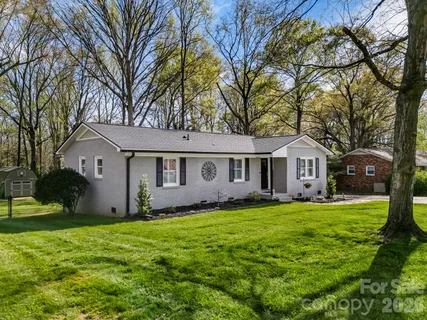a view of a yard in front of a house with large tree