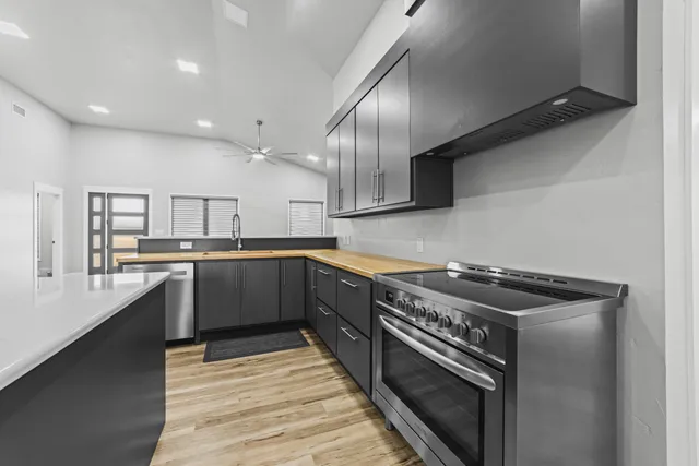 a kitchen with stainless steel appliances a sink dishwasher a stove top oven and cabinets