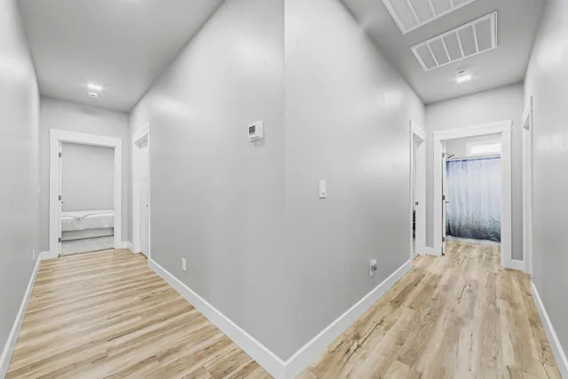 a view of a hallway with wooden floor