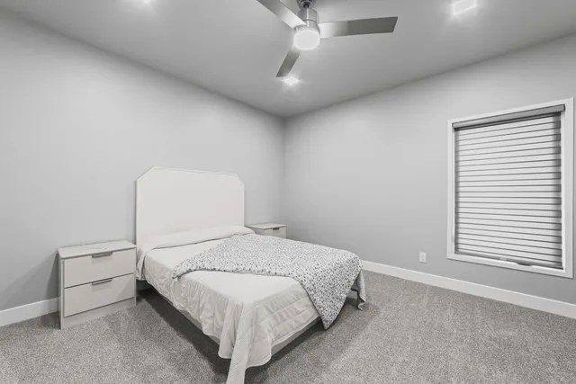 a bedroom with a bed and a large window