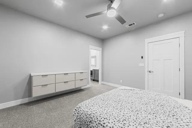 a bedroom with a bed and a chandelier fan