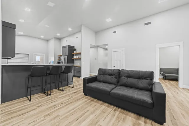a living room kitchen with furniture and a wooden floor