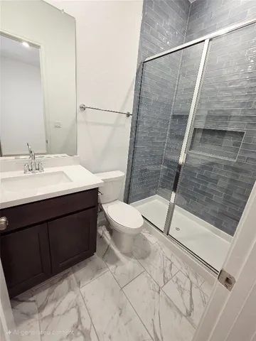 a bathroom with a sink a toilet a mirror and shower