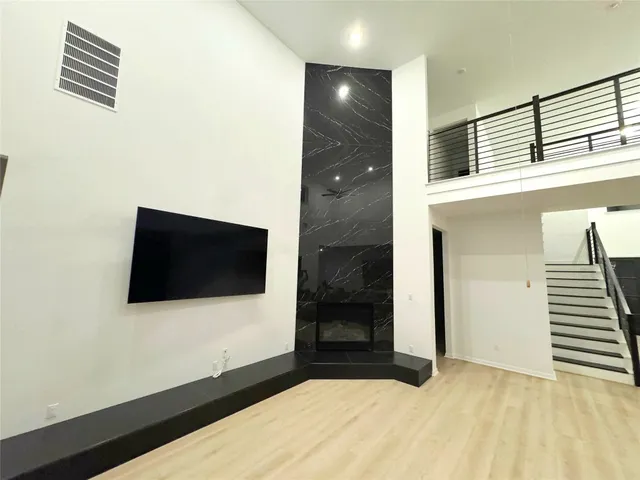 a view of a living room with a flat tv screen and wooden floor