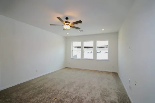 an empty room with a window and a ceiling fan