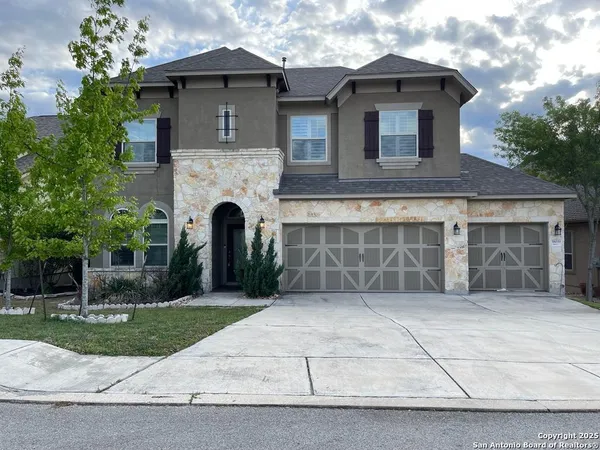 a front view of a house with a garden and garage