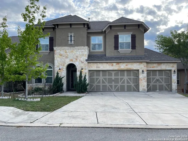 a front view of a house with a garden and garage