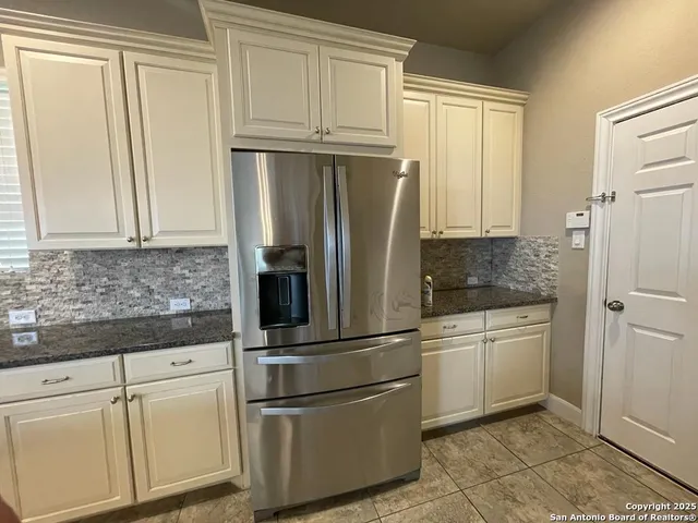 a kitchen with granite countertop a sink a stove and cabinets