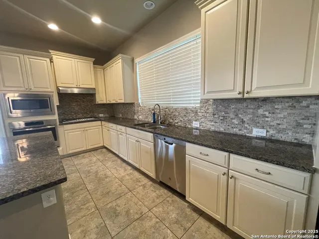 a kitchen with stainless steel appliances granite countertop sink stove and cabinets