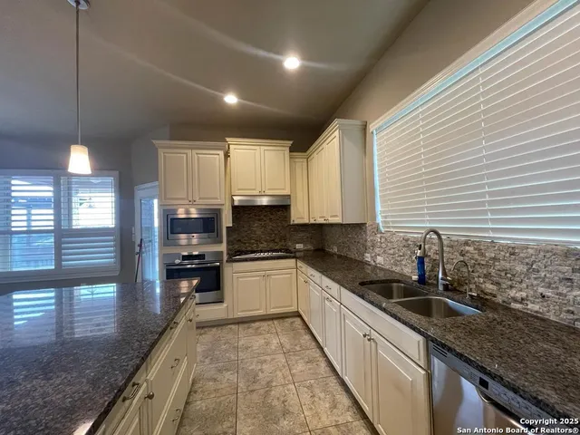 a large kitchen with kitchen island granite countertop a large counter top stainless steel appliances and cabinets
