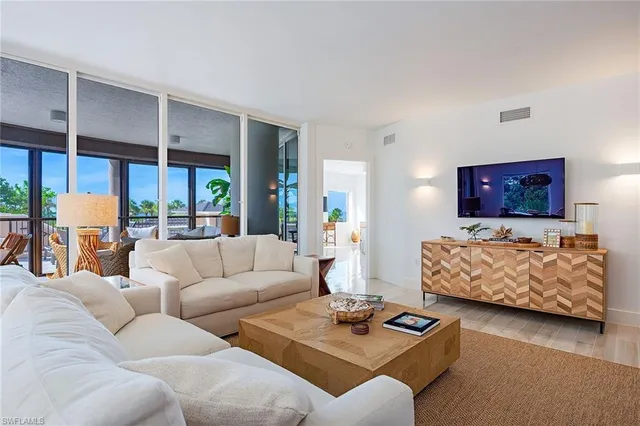 a living room with furniture and a floor to ceiling window