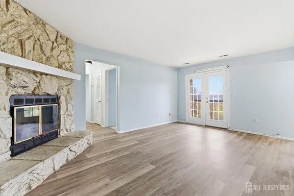a view of empty room with wooden floor and fireplace