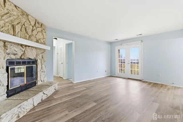 a view of empty room with wooden floor and fireplace