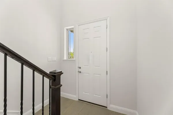 a view of a hallway with wooden floor and entryway