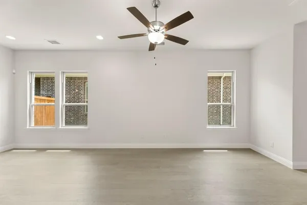 an empty room with a window and a ceiling fan