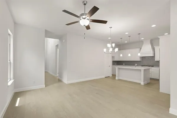 a view of an empty room and kitchen view