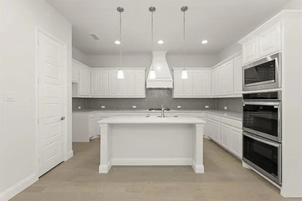 a view of a kitchen with a sink oven and cabinets